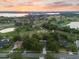 Breathtaking aerial view of the property, golf course, lake, and surrounding neighborhood at sunset at 6054 Tarawood Dr, Orlando, FL 32819