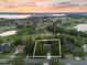 Beautiful aerial view of a home nestled on a golf course with lake and sunset views at 6054 Tarawood Dr, Orlando, FL 32819