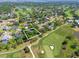 An aerial view highlights the home's location on a golf course, near a lake, with mature trees and landscaped yards at 6054 Tarawood Dr, Orlando, FL 32819