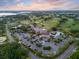 This aerial shows a golf club with a large parking lot surrounded by lush landscapes and homes near a tranquil lake at 6054 Tarawood Dr, Orlando, FL 32819