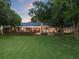 Expansive backyard featuring a covered patio with outdoor seating, a lush lawn, and mature trees for privacy and relaxation at 6054 Tarawood Dr, Orlando, FL 32819
