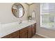 Bathroom with white sink, wood cabinets, and window offering natural light at 6054 Tarawood Dr, Orlando, FL 32819