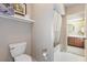 Bright bathroom with white toilet, shower-tub combo and wood cabinets at 6054 Tarawood Dr, Orlando, FL 32819