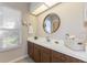 Bathroom featuring a white countertop, a round mirror, dark wood cabinets, and a window at 6054 Tarawood Dr, Orlando, FL 32819