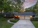 Charming single-story home featuring a large driveway, side-entry garage, mature trees, and landscaping at 6054 Tarawood Dr, Orlando, FL 32819