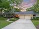 Inviting home featuring a two-car garage, walkway, and vibrant landscaping at 6054 Tarawood Dr, Orlando, FL 32819
