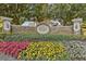 Decorative stone Bay Hill entrance sign surrounded by colorful flowers, greenery, and mature trees at 6054 Tarawood Dr, Orlando, FL 32819