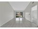 Spacious living room featuring bright white tile flooring and sliding glass doors to a screened patio at 66 Silver Falls Cir, Kissimmee, FL 34743