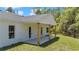 Rear exterior view showcasing a covered patio with wooden support columns and white trim at 6725 Sw 131St Cir, Ocala, FL 34481