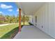 View of the side of the home and yard from the covered patio with stained wood posts at 6725 Sw 131St Cir, Ocala, FL 34481