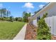 Charming white farmhouse with a manicured lawn, mature trees, a walkway, and decorative landscaping at 6725 Sw 131St Cir, Ocala, FL 34481