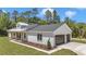A beautifully landscaped modern farmhouse with attached two-car garage and a metal roof at 6725 Sw 131St Cir, Ocala, FL 34481