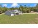 Exterior view of a charming home with a covered porch, wooden pillars, and an extended driveway at 6725 Sw 131St Cir, Ocala, FL 34481