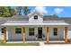 Charming farmhouse-style home with a welcoming front porch and natural wood supports at 6725 Sw 131St Cir, Ocala, FL 34481