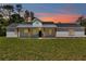 Attractive single story house at sunset features white siding and a inviting front porch at 6725 Sw 131St Cir, Ocala, FL 34481