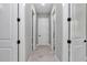 Hallway with white doors and matte black hardware, leading to various rooms at 6725 Sw 131St Cir, Ocala, FL 34481