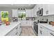Bright kitchen boasts white cabinets, a large island, stainless appliances, and a window offering beautiful outdoor views at 6725 Sw 131St Cir, Ocala, FL 34481