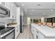 Modern kitchen with stainless steel appliances, quartz countertops, and an island open to the living area at 6725 Sw 131St Cir, Ocala, FL 34481