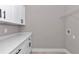 A well-lit laundry room featuring white cabinets, a quartz countertop, and a wire shelf at 6725 Sw 131St Cir, Ocala, FL 34481