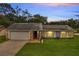 Charming single-story home with stone accents, well-manicured lawn, solar panels, and attached garage at dusk at 819 Haulover Dr, Altamonte Springs, FL 32714