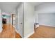 Hallway with hardwood floors leading to a cozy living room with a fireplace, and a glimpse into the kitchen at 819 Haulover Dr, Altamonte Springs, FL 32714