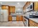 Well-lit kitchen features wood cabinets, stainless steel appliances, granite counters, and tile backsplash at 819 Haulover Dr, Altamonte Springs, FL 32714