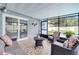 Screened-in patio boasts cozy seating, patterned tile flooring, and tranquil backyard views at 819 Haulover Dr, Altamonte Springs, FL 32714