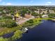 Aerial view showcases the home's location near a lake with a dock and lush surrounding landscape at 955 Seminole St, Clermont, FL 34711