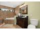 Bathroom featuring a soaking tub, vanity with sink, and a framed mirror for a spa-like retreat at 955 Seminole St, Clermont, FL 34711