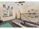 Upper bonus room with ceiling fan, exercise equipment, and railing overlooking the first floor at 955 Seminole St, Clermont, FL 34711