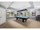 Large game room with a pool table under a pendant light and natural light from windows at 955 Seminole St, Clermont, FL 34711