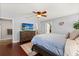 Relaxing main bedroom featuring a ceiling fan, TV, and views into the ensuite bathroom and walk-in closet at 955 Seminole St, Clermont, FL 34711
