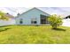Back exterior view showing light-blue paint, large yard, and screened patio space at 11547 Grazeley Ct, Orlando, FL 32837