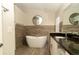 Modern bathroom featuring a soaking tub and granite vanity at 11547 Grazeley Ct, Orlando, FL 32837