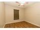Cozy bedroom features wood-look flooring, window with blinds, and a playful ceiling fan at 11547 Grazeley Ct, Orlando, FL 32837