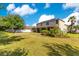 Expansive backyard with lush green lawn, basketball court, privacy fence, and covered patio of the home at 12636 Hammock Pointe Cir, Clermont, FL 34711