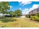 Spacious backyard with a basketball court, well-maintained lawn, and landscaped garden area with beautiful blooms at 12636 Hammock Pointe Cir, Clermont, FL 34711