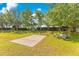 Backyard features a basketball court, seating, and mature trees at 12636 Hammock Pointe Cir, Clermont, FL 34711