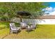 Backyard featuring an outdoor seating area with comfortable chairs and umbrella at 12636 Hammock Pointe Cir, Clermont, FL 34711