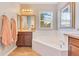 Bright bathroom with vanity and storage, jacuzzi bathtub, and window allowing for natural light at 12636 Hammock Pointe Cir, Clermont, FL 34711