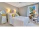 Bright bedroom featuring a comfortable queen bed, end table, and stylish coastal-themed decor at 12636 Hammock Pointe Cir, Clermont, FL 34711