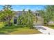 Two-story home exterior featuring a manicured lawn, palm trees, and a driveway leading to a two-car garage at 12636 Hammock Pointe Cir, Clermont, FL 34711