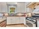 A close-up of the kitchen with white cabinets, granite countertops and stainless steel appliances at 12636 Hammock Pointe Cir, Clermont, FL 34711