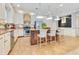 Well-lit kitchen with an island, stainless steel appliances, pendant lighting, and stylish barstool seating at 12636 Hammock Pointe Cir, Clermont, FL 34711