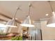 Pendant lights illuminate an island, stainless steel appliances, and countertops at 12636 Hammock Pointe Cir, Clermont, FL 34711