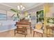 Bright living area featuring a piano, tile flooring, and a chair by the sunlit window at 12636 Hammock Pointe Cir, Clermont, FL 34711