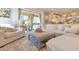 Open-concept living space with a large sofa, glass doors, and natural light at 12636 Hammock Pointe Cir, Clermont, FL 34711