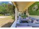 Inviting covered patio with a sofa and dining table, and lush landscaping at 12636 Hammock Pointe Cir, Clermont, FL 34711