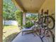 Inviting covered patio with a lounge chair, seating area, and lush landscaping at 12636 Hammock Pointe Cir, Clermont, FL 34711