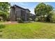 A spacious backyard featuring a screened-in lanai, lush green lawn, and mature trees providing shade and privacy at 14037 Fairway Willow Ln, Winter Garden, FL 34787